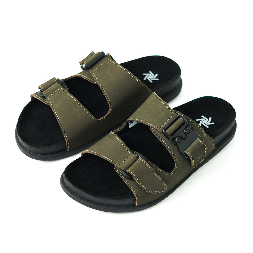Pair of green sandals with black soles on a white background