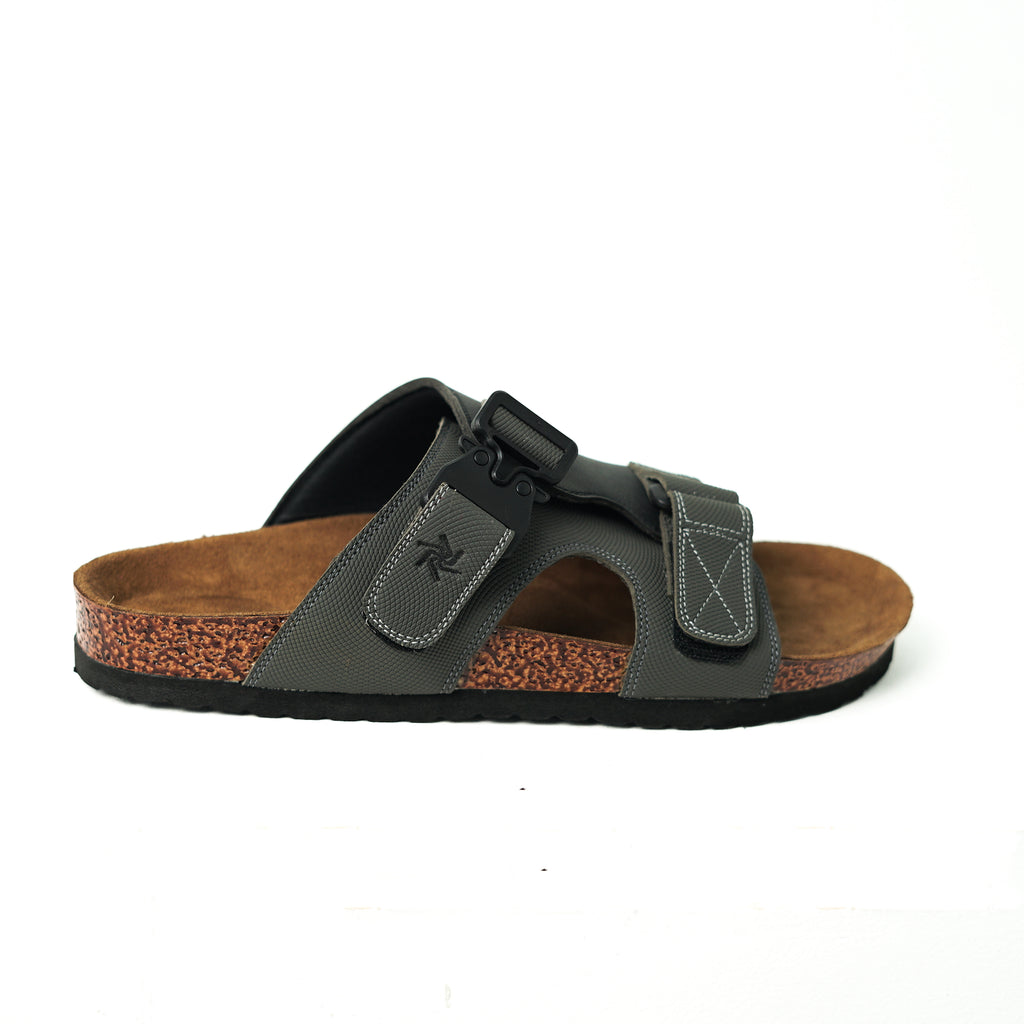 Black sandal with brown sole on a white background
